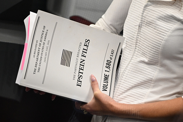 A woman holds documents titled 